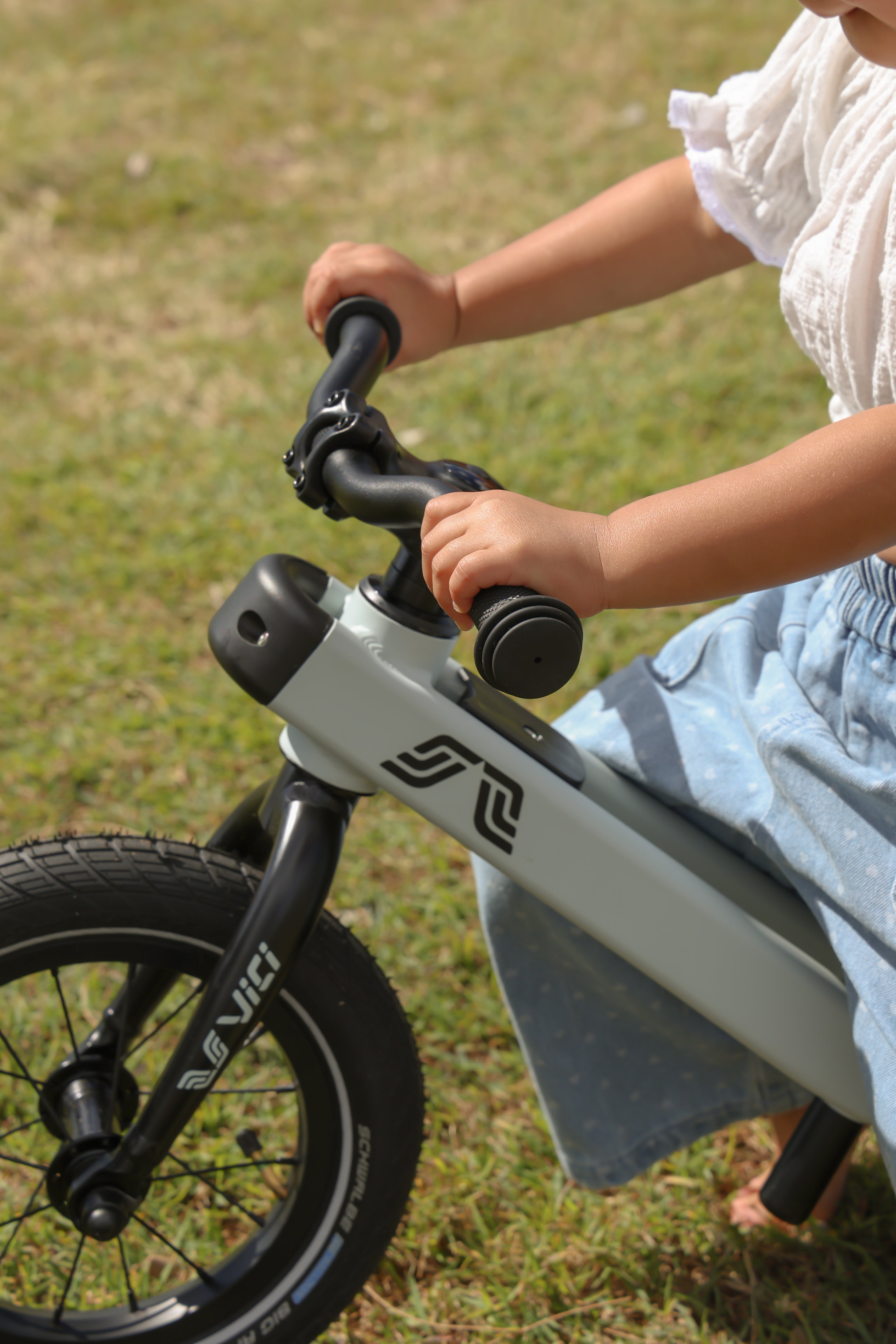 Balance bike toddler riding stage bike on the grass